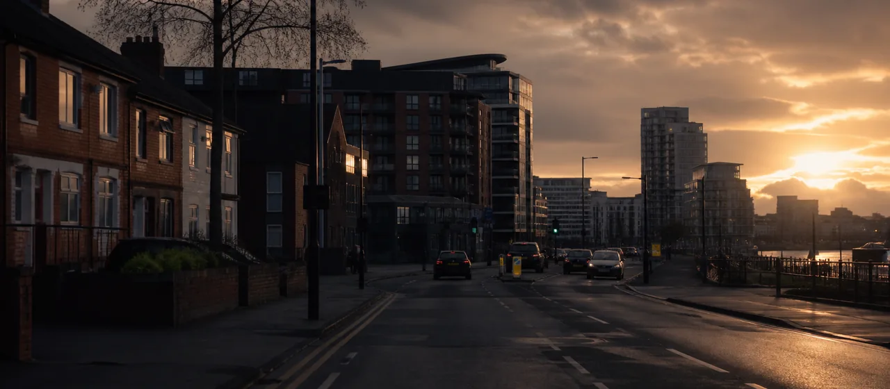 Road transitioning from brick housing to a modern Salford-style urban district
